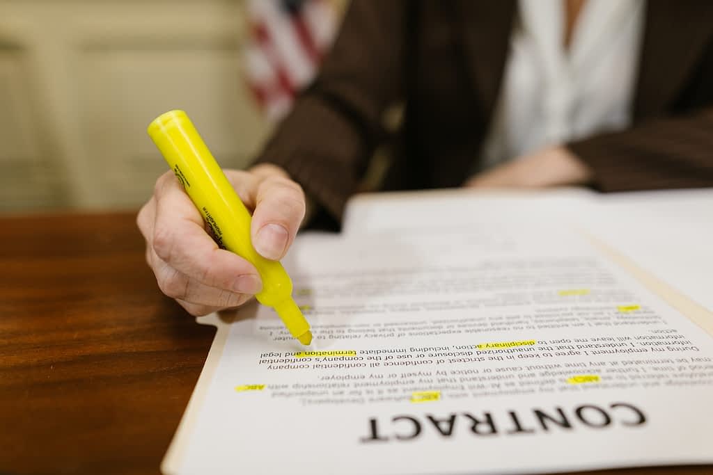 Picture of woman highlighting text on a contract.