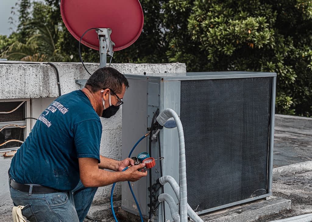 HVAC technician repairing a roof-top airconditioner.
