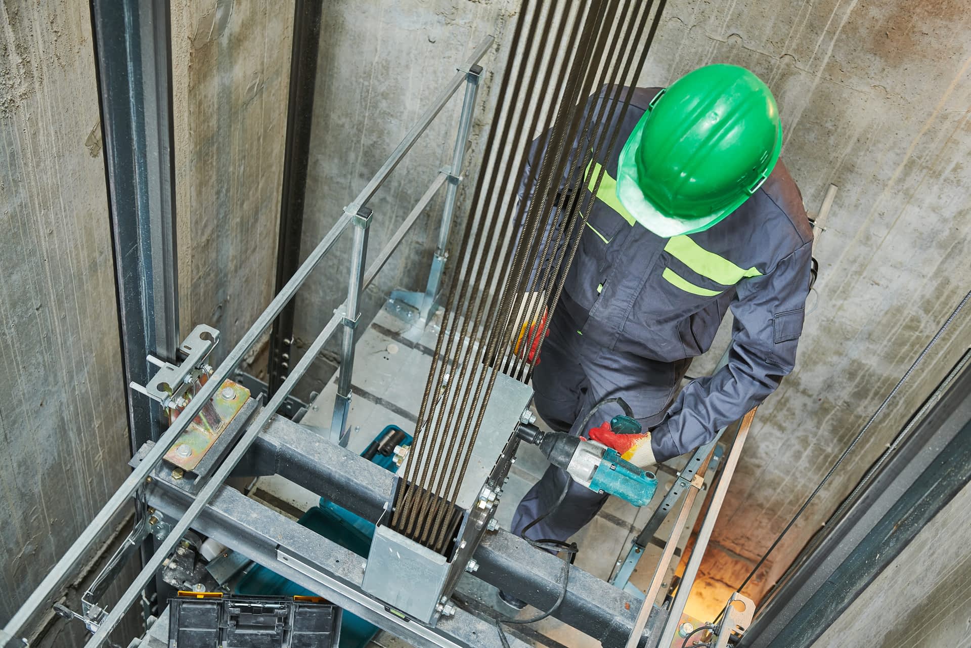 lift machinist repairing elevator in lift shaft